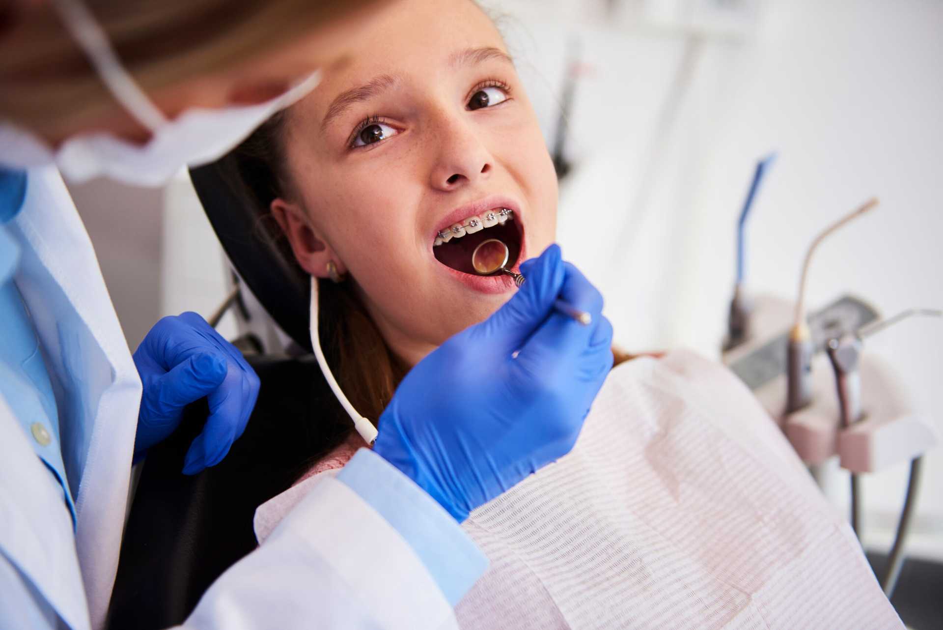Part,of,orthodontist,examining,child's,teeth,in,dentist's,office